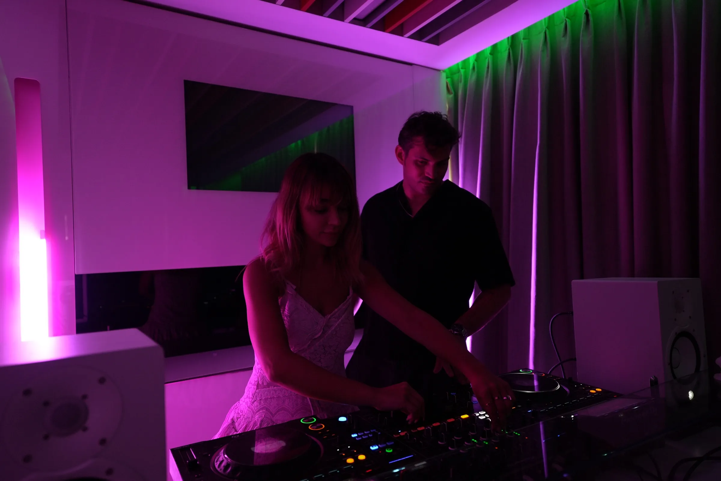 AXIOM stüdyosunda DJ ekipmanı başındaki katılımcılar.